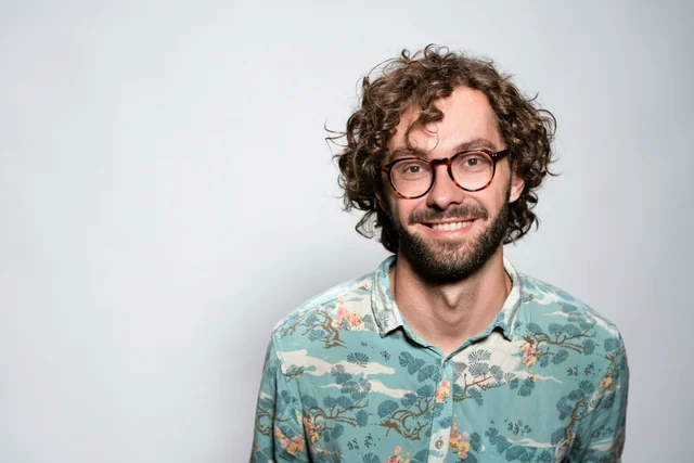 Original reference photo of a man with round glasses and a beard wearing a patterned shirt.