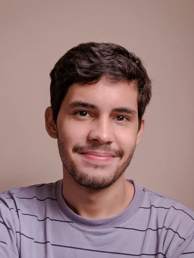 Original Samsung phone photo of a man with short dark hair and facial hair wearing a striped T-shirt.